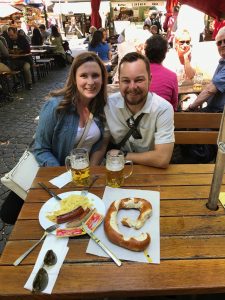 Caitlin and Tucker enjoying a pretzel at bratwurst at a biergarten.