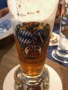 A small taster glass of beer with crests on it.