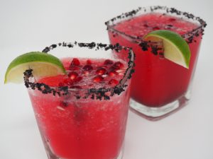 Two pink margaritas with a black salt rim