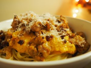 A bowl of pasta topped with pumpkin pasta sauce.