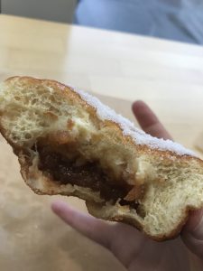 A donut cut in half with apple butter inside.