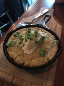 A cornmeal pancake in a small cast iron pan.