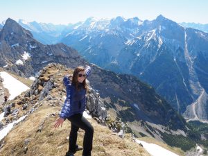 Caitlin posing on the top of the alps in Germany.