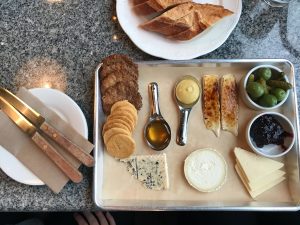 A tray with cheeses and other small bites.