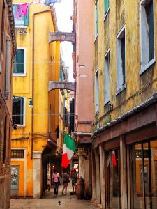 A small Italian alley with arches joining the buildings.