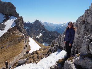 Caitlin standing on the top of the mountain peak.