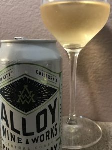 A can of Alloy Wine Works wine with a glass in the background.