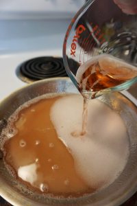 A pan on the stove with simple syrup cooking.