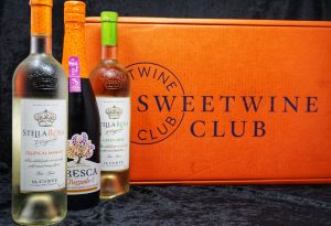 A bright orange box with three bottles of wine.