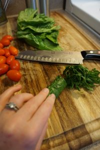 Cutting board with tomatoes and spinach.