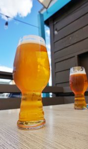 Two glasses of beer on a table.