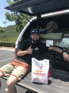 Oakley and Tucker in the back of the truck with a bag of In N Out Burger.