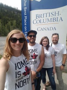 Four adults standing in front of the British Columbia sign.