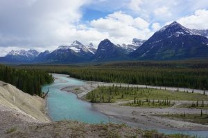 A turquoise river flowing alongside mountains.