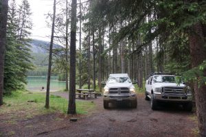 Two trucks parked in front of Two Jack Lake in Canada.