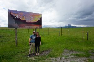 Tucker and Caitlin posing in front of the Montana sign.