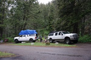 Two trucks parked at a campsite.