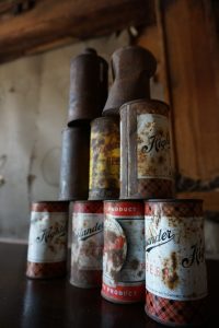 A stack of nine rusting Highlander Beer cans.