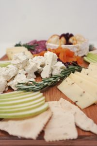 A close up view of fruits on a cheese board.