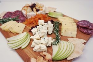 A close-up view of cheese on a wooden board.