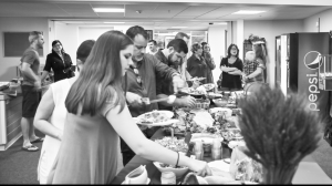 A line of people filling their plates at a buffet table.