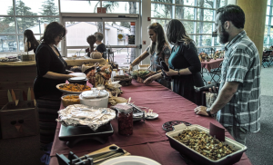 Four people gathered around a table with Thanksgiving food.