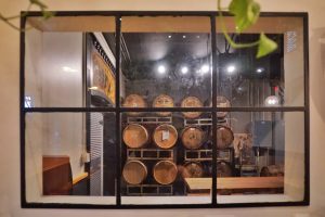 A photo of a window with barrels in the background.