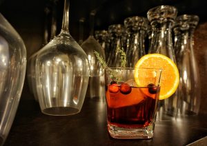 A negroni cocktail with glassware in the background.