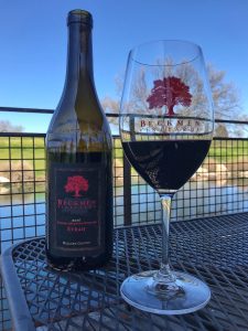 A bottle of Beckmen Vineyards Syrah alongside a glass of the Syrah.