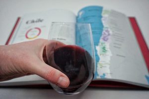 Caitlin holding a glass of pinot noir from a can