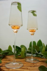 Two champagne glasses with a cocktail inside.