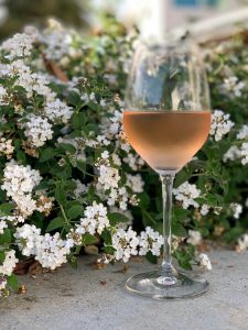 Vertical photo of Rosé glass with flowers.