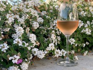 Glass of Rosé with flowers in the background.