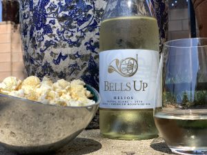 Bells Up Helios with a glass and popcorn. 