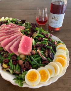 Photo of salad and wine featuring jammy hardboiled eggs