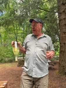 Rich Cushman holding a bottle of his sparkling wine.