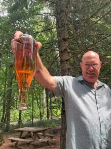 Rich demonstrating what yeast beads look like in sparkling wine.